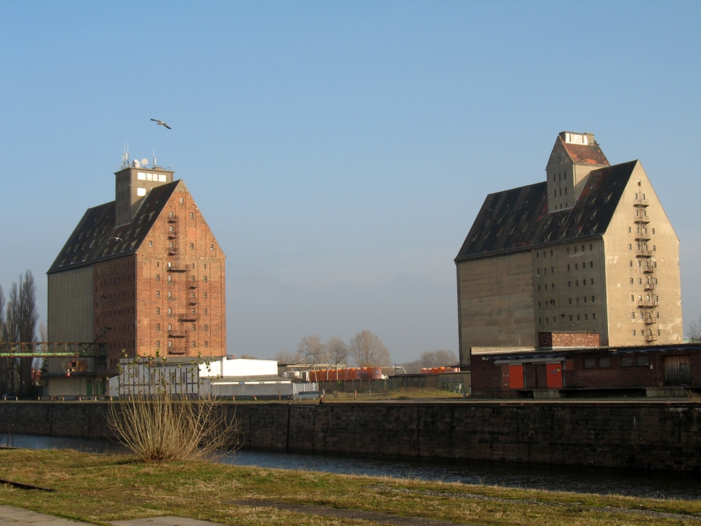 Zwei alte Speichergebäude am Wasser bei Sonnenschein.